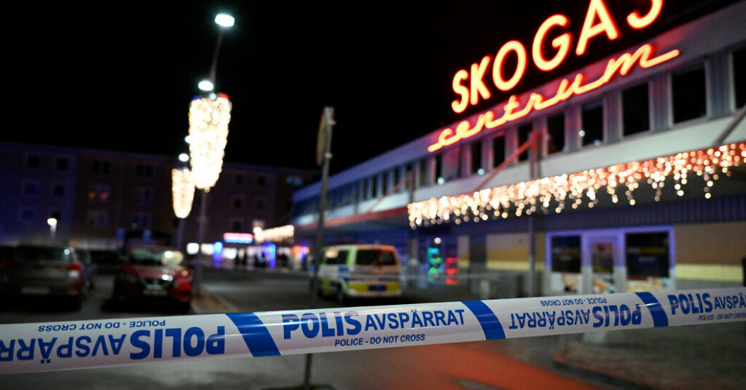 Polisavspärrningar vid brottsplatsen i Skogås centrum, där den 15-årige pojken sköts ihjäl i slutet av januari i år. Arkivbild. Ännu en misstänkt för mord på pojke i Skogås
