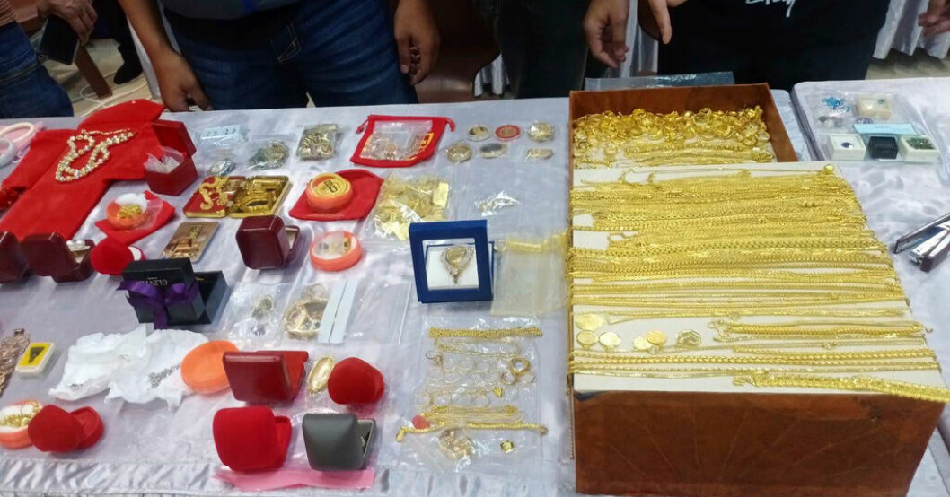 Polisen visar upp guld och andra smycken som beslagtogs vid räden mot buddisttemplet i den thailändska provinsen Nakhon Ratchasima. Munkar misstänks för miljonförskingring