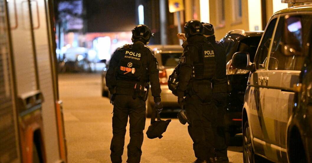 Poliser på gatan med bilar bredvid sig.