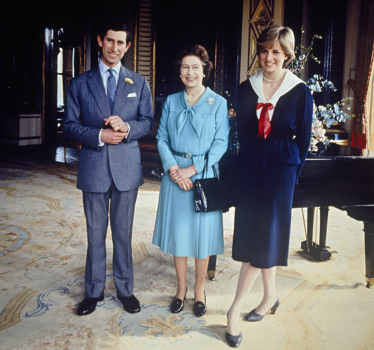 Här ser man hur Diana, som förvisso har klackar, försöker göra sig lite kortare bredvid prins Charles och drottning Elizabeth II. Prins Charles, drottning Elizabeth II och prinsessan Diana.