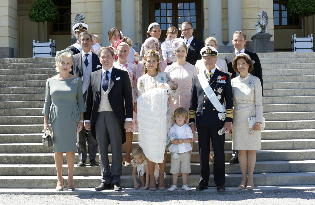 Prinsessan Leonore gömmer sig bakom mammas ben på familjefotot.