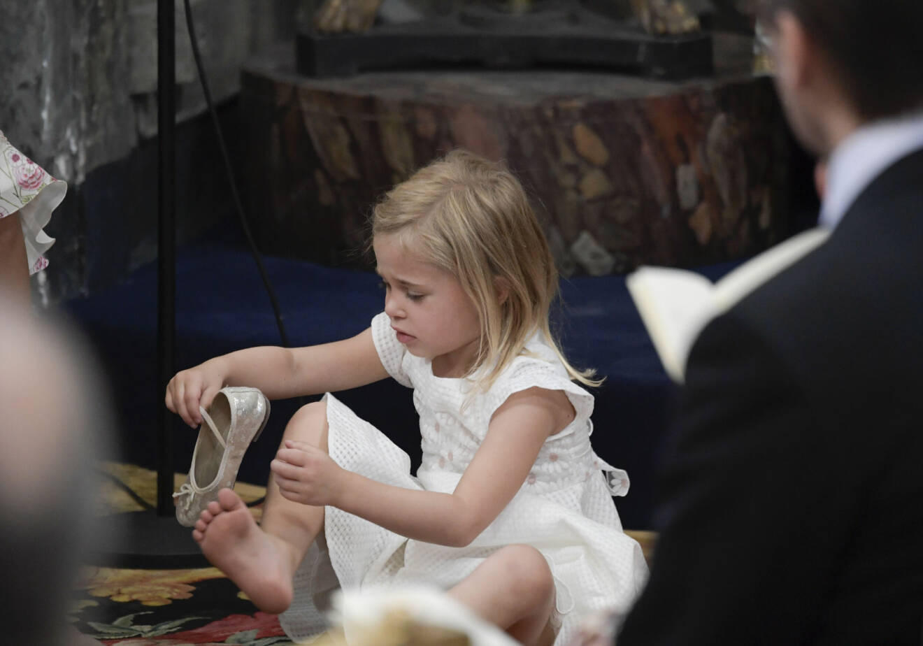 Prinsessan Leonore leker med skorna på golvet under prinsessan Adriennes dop.
