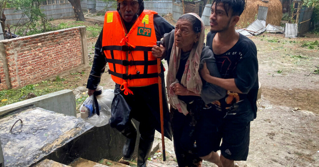 Räddningsarbetare hjälper en kvinna att söka skydd i Teknaf nära Cox's Bazar. Cyklon når Bangladesh – 1,5 miljon barn i fara