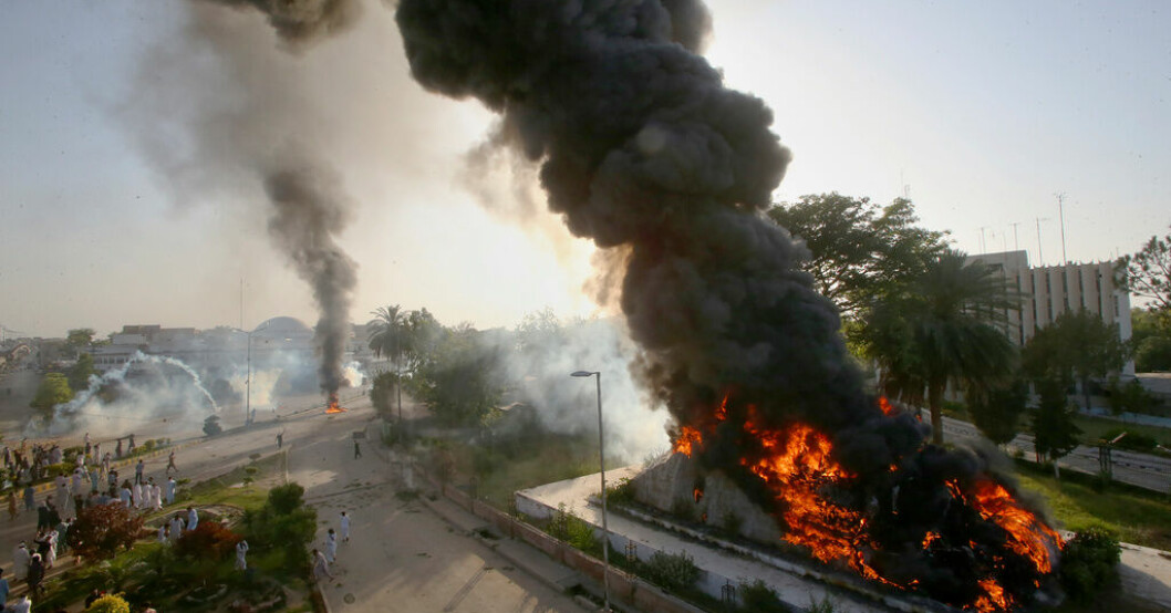 Röken stiger från de eldar som demonstranter startat i Peshawar i Pakistan. Våldsamheter i Pakistan – ex-ledare gripen