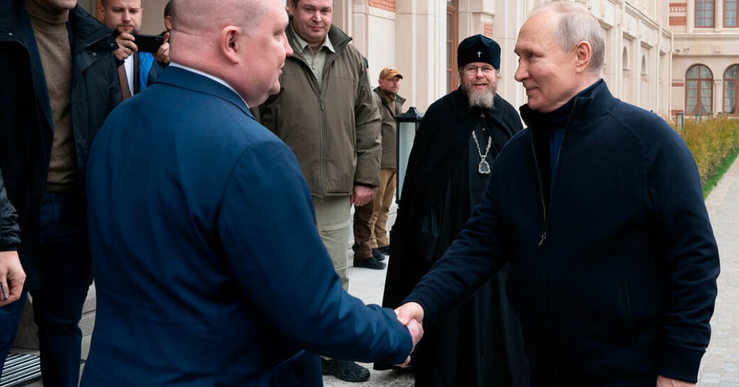 Rysslands president Vladimir Putin hälsar på den av Ryssland tillsatte guvernören Michail Razvozjajev. Putin besökte Krim på årsdag