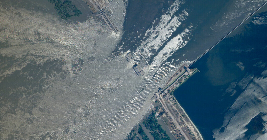 Satellitbild över kraftverksdammen Kachovka, där vattnet forsar fram. Tiotusentals evakueras från vattenmassorna