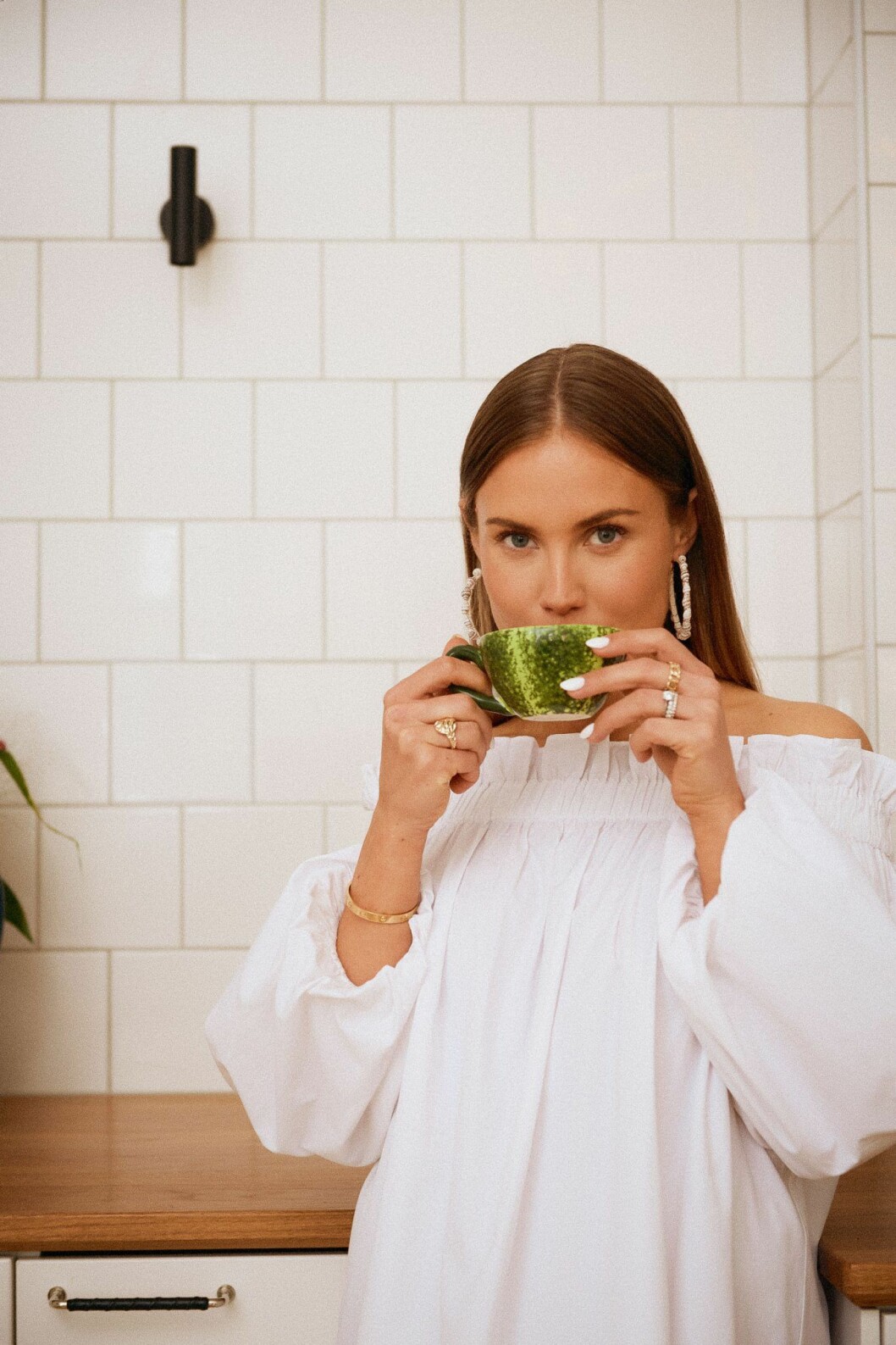 Tjej med vit topp som dricker från en mugg