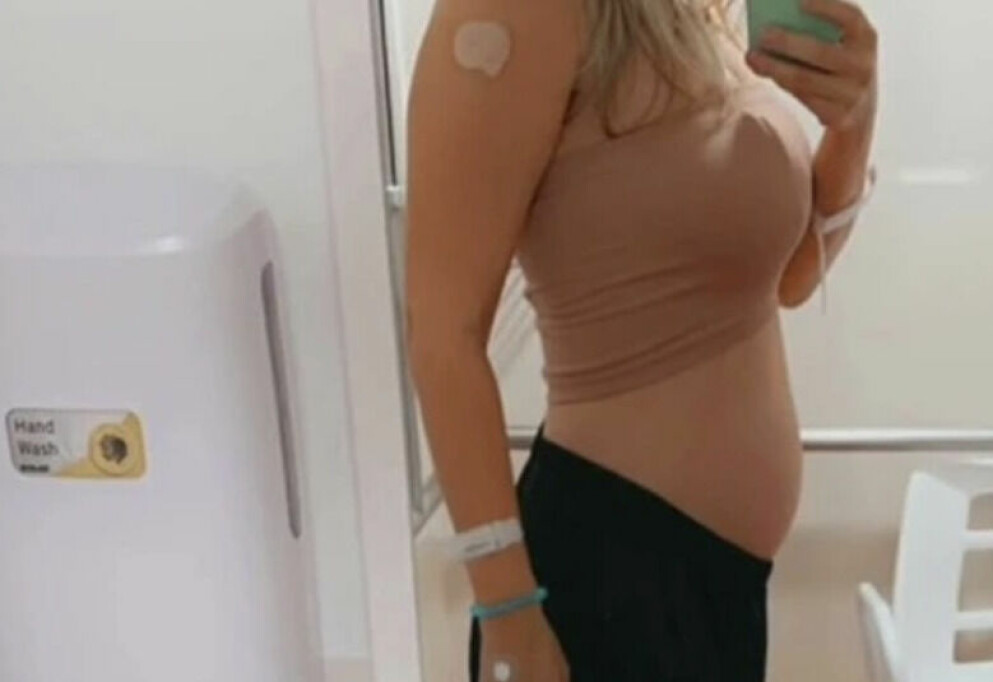 På bilden visar mamman upp sin pyttelilla mage – dagen då hon födde.