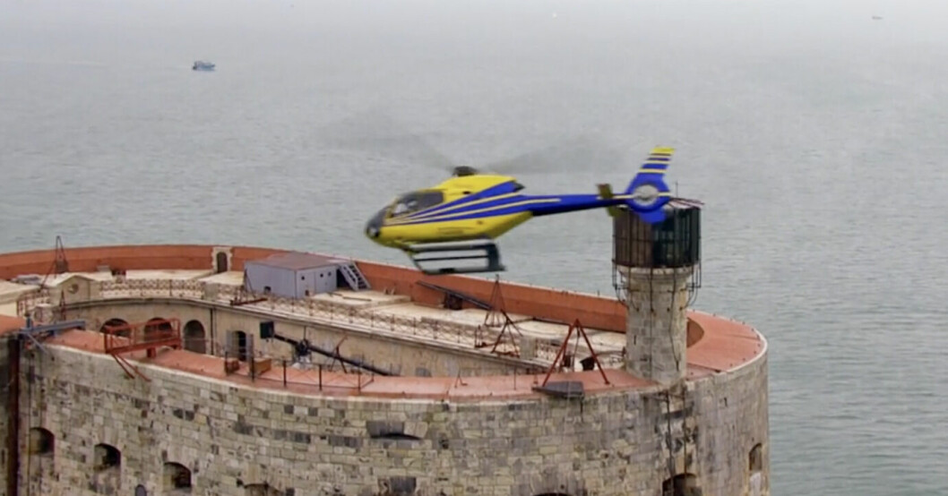 En helikopter flyger över Fångarna på fortet-fortet