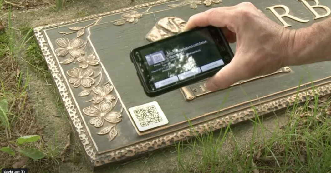 En mobil som scannar en qr-kod på en gravsten.