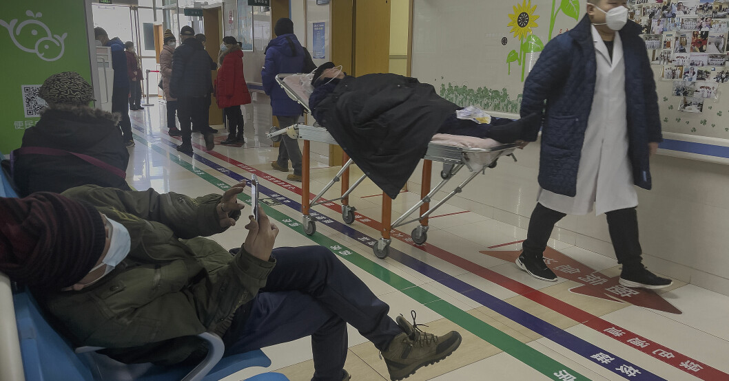 Ett sjukhus i Kina där folk bär mask och en ligger på en brits.