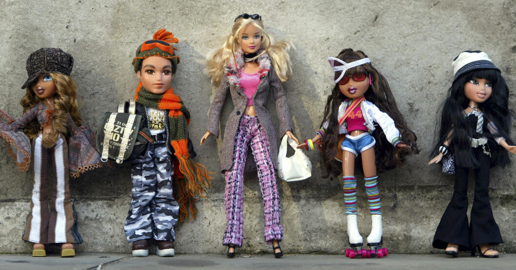Bratz-dockor tillsammans med en Barbie-docka som står i mitten.