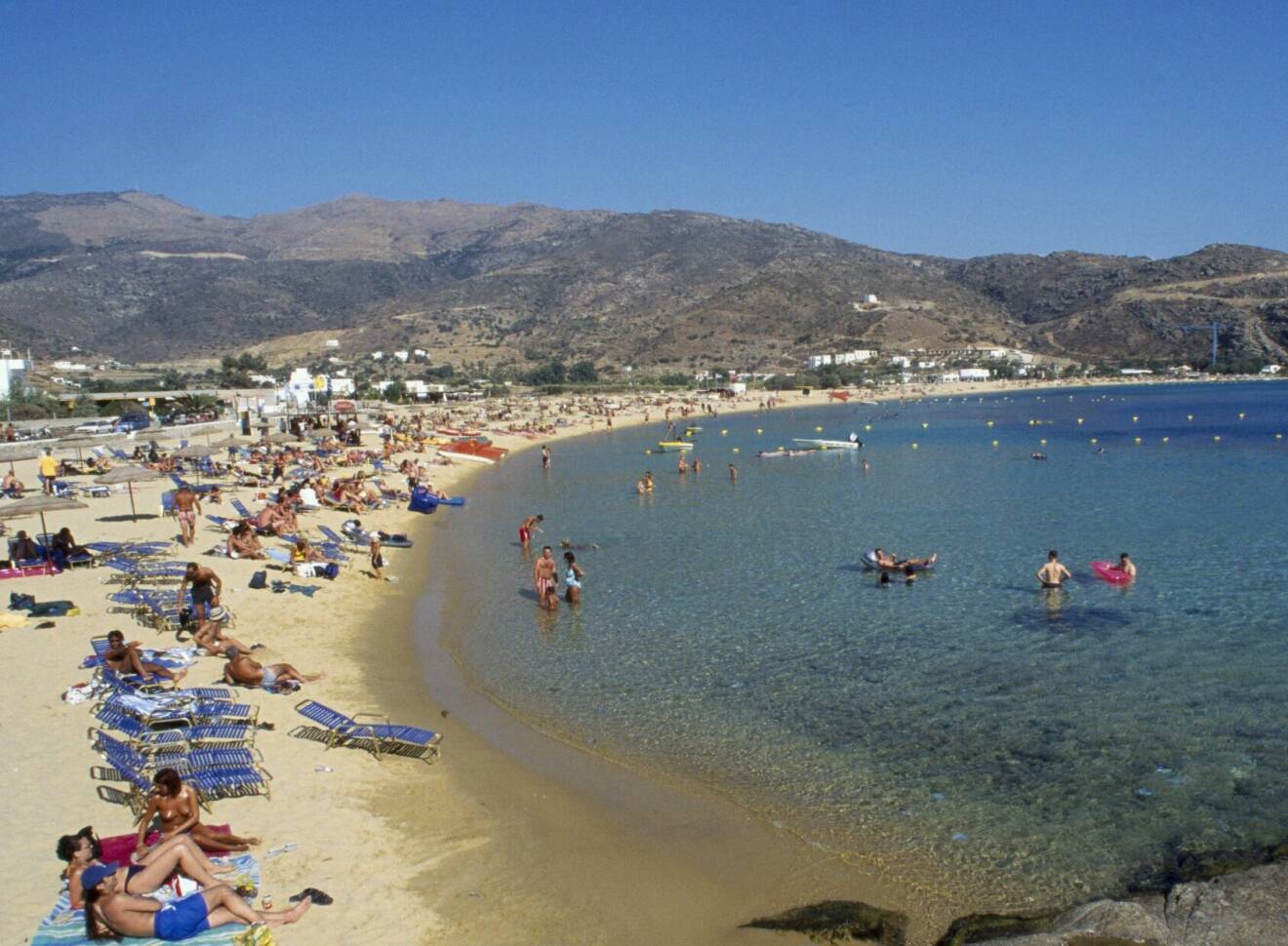 Milopotas Beach på västra Ios är en populär sandstrand för badsugna semesterfirare.