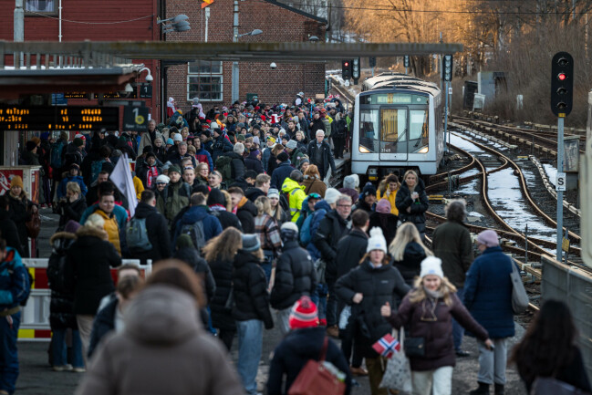 Tiotusentals besökare söker sig från Oslo till Holmenkollen för att heja på vid sidan av spåret. Besökare väntar på tåget till Holmenkollen.