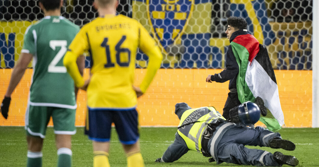 Planen stormades av flera algeriska supportrar. En ordningsvakt slänger sig på marken i ett misslyckat försök att få fatt i en av planstormarna.