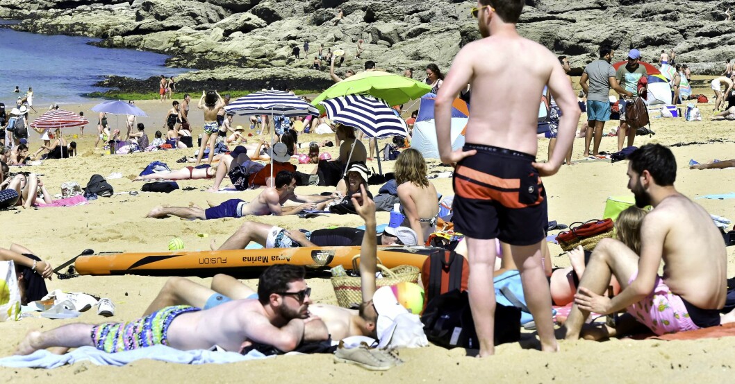 Människor ligger på en strand och solar. Folk på en strand