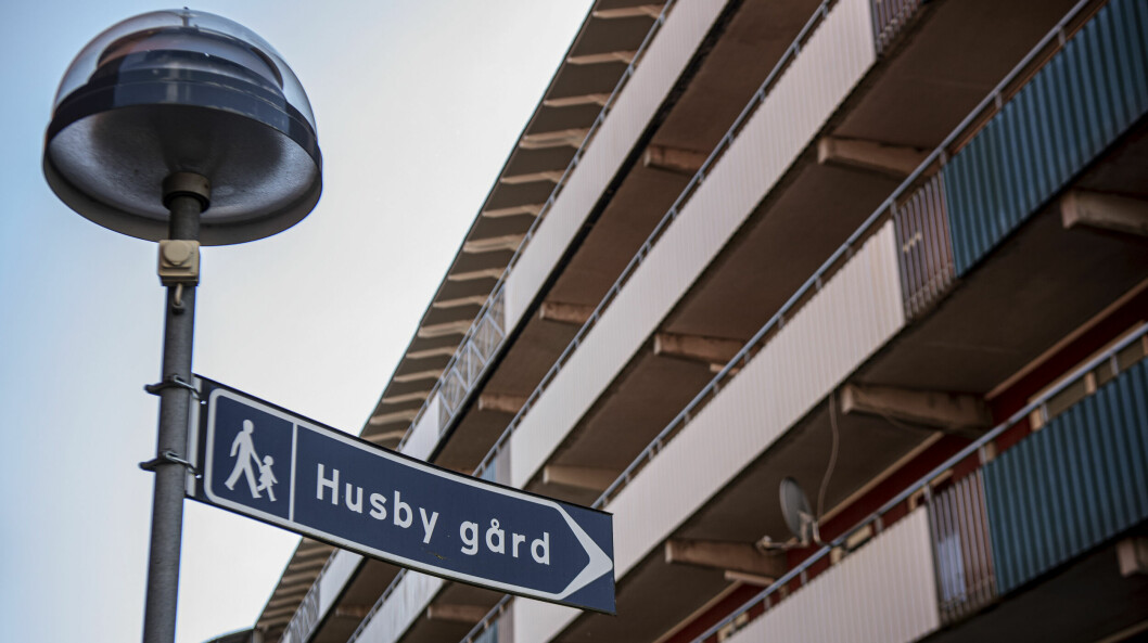 <strong>Bara ett par hundra meter från förskola och skola sköts en man till döds.</strong> Skylt och balkonger i förorten Husby