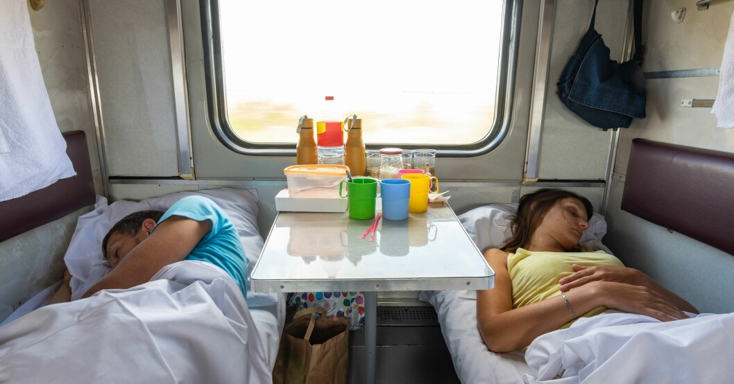 Två personer som sover i bäddar på ett tåg.