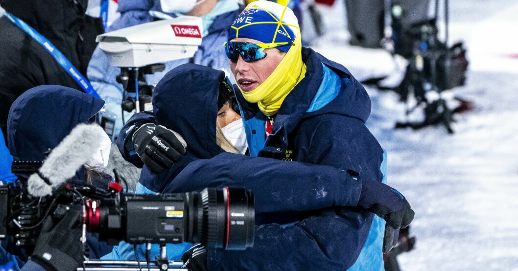 William Poromaa tröstas av flickvännen Frida Karlsson när Sverige blir fyra i herrarnas sprintstafett under vinter-OS i Peking 2022.