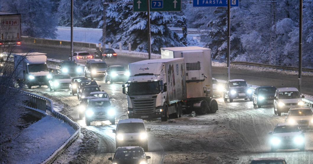 Snöig väg i Stockholm, flera bilar.
