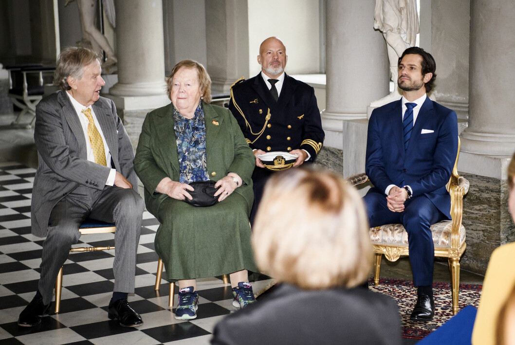Elisabeth Douglas, 80, i mitten av bilden. Här i grön klänning och fotriktiga skor, tillsammans kungligt sällskap med prins Carl Philip.