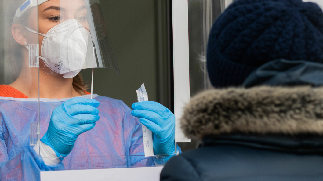 <strong>För att få ett giltigt testbevis måste coronatestet utföras av behörig personal.</strong> Vårdpersonal utför coronatest på äldre kvinna.