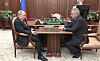 Vladimir Putin och försvarsminister Sergej Sjojgu ser påtagligt märkta ut. Putin ser ut att greppa bordet för att hålla sig i balans. Vladimir Putin och Sergej Sjojgu