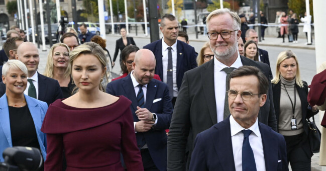 Ebba Busch (KD), Johan Pehrson (L) och Ulf Kristersson (M) går ihop med den nya regeringen utanför Rosenbad i Stockholm.