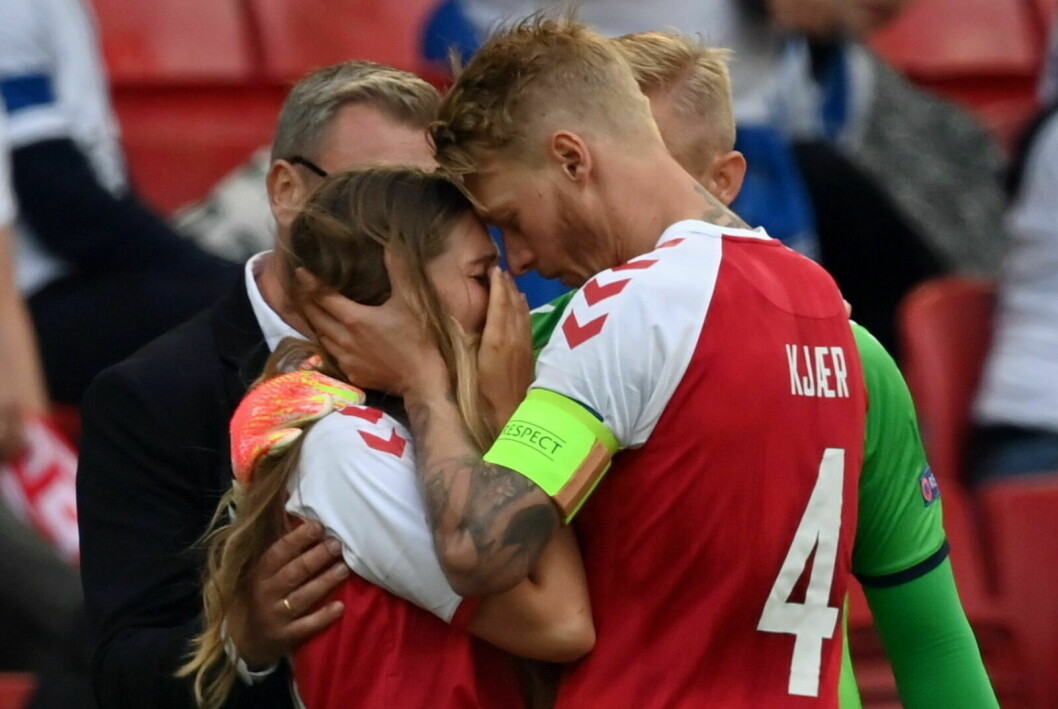 <strong>Simon Kjær tröstar Christian Eriksens fru Sabrina efter makens kollaps på planen.</strong> Simon Kjær tröstar Christian Eriksens fru Sabrina efter makens kollaps på fotbollsplanen.
