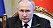Vladimir Putin sitter framför en mikrofon.
