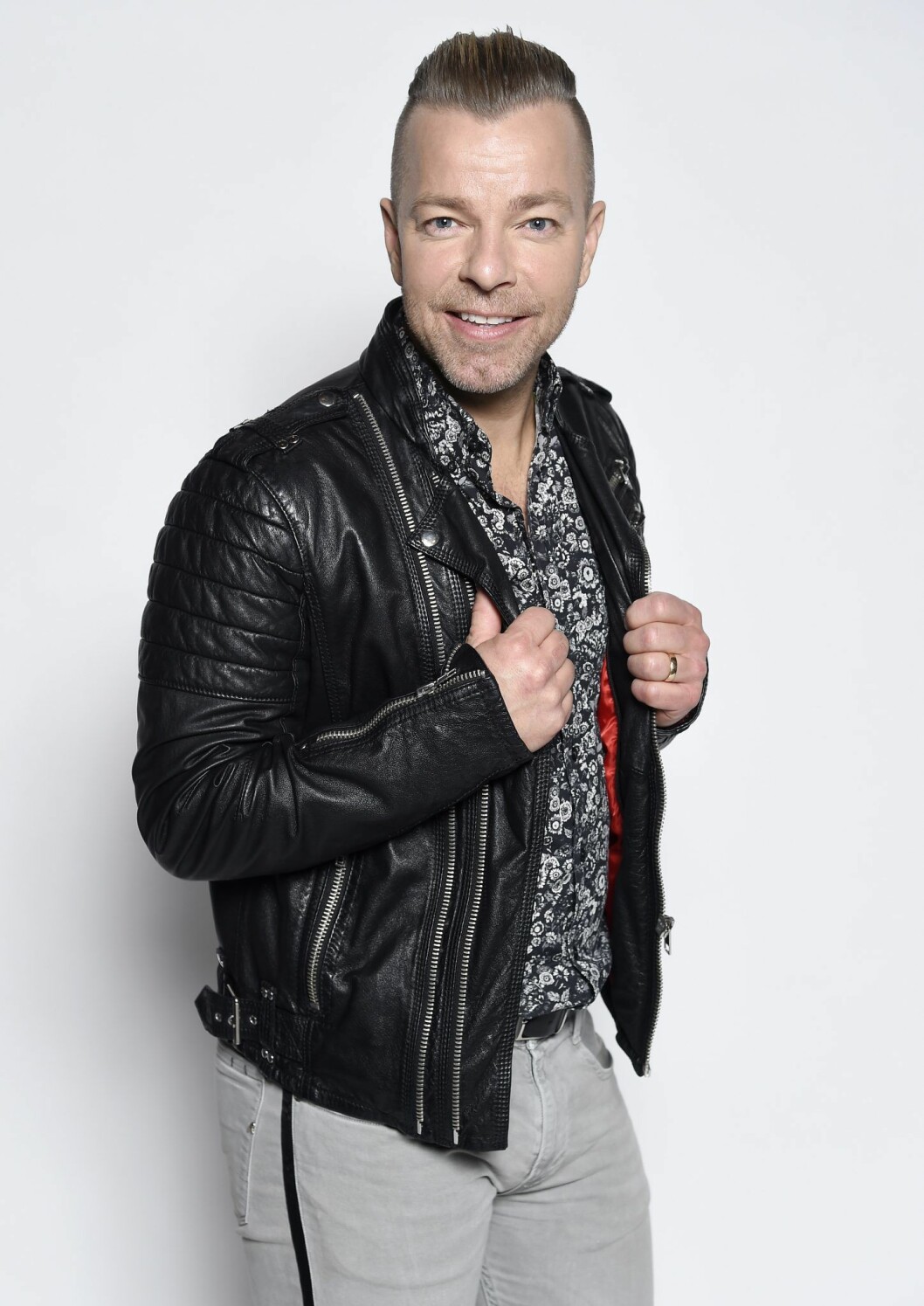 Casper Janebrink. Casper Janebrink har på sig en svart skinnjacka och skrattar mot kameran