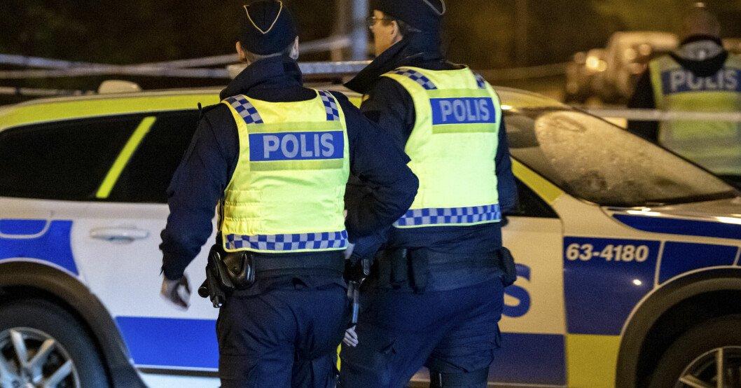 Två poliser framför en polisbil.