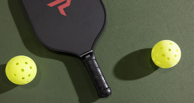 Pickleballracket med tillhörande bollar. En sport som blir större och större i USA. Pickleballracket med tillhörande bollar. En sport som blir större och större i USA.