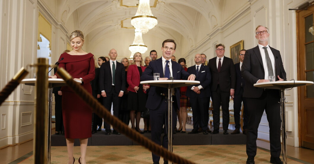 Ebba Busch, Ulf Kristersson och Johan Pehrson med den tillträdande regeringen i bakgrunden. Ensemblen samlades tillsammans för första gången. Busch (KD), Kristersson (M) och Pehrson (L).