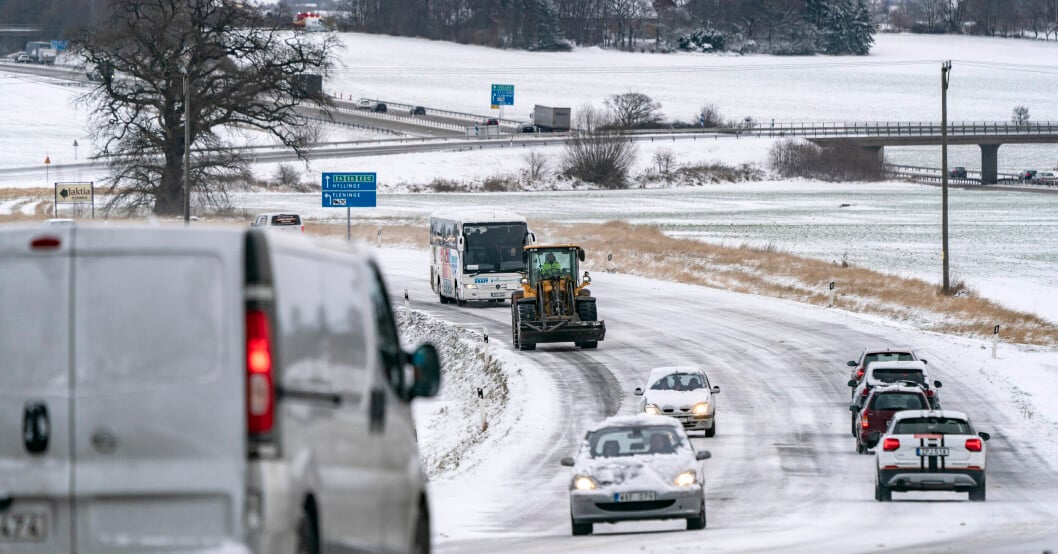 Flera fordon kör på en snötäckt väg.
