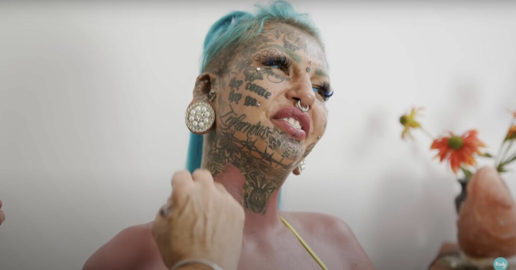 Amber sminkar över sina tatueringar. Amber