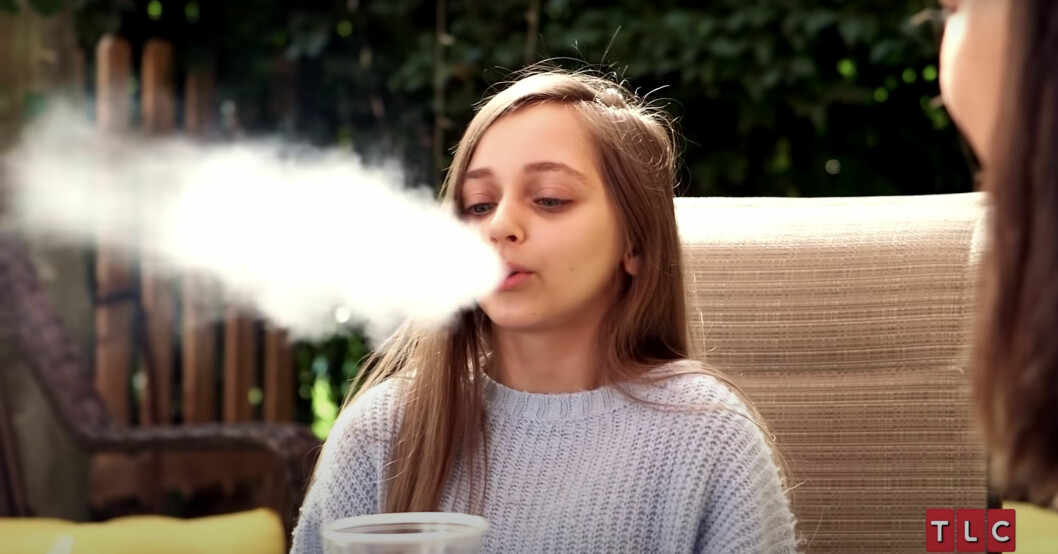 Shauna Rae, 22, blåser ut något som ser ut att komma från en cigarett. Shauna Rae