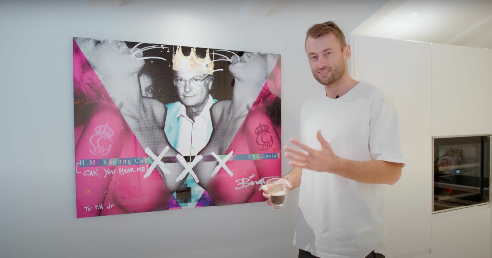 Med en kopp kaffe i handen berättar Petter Northug om tavlan som föreställer Kung Carl Gustaf med två nakna kvinnor bredvid sig. Petter Northug