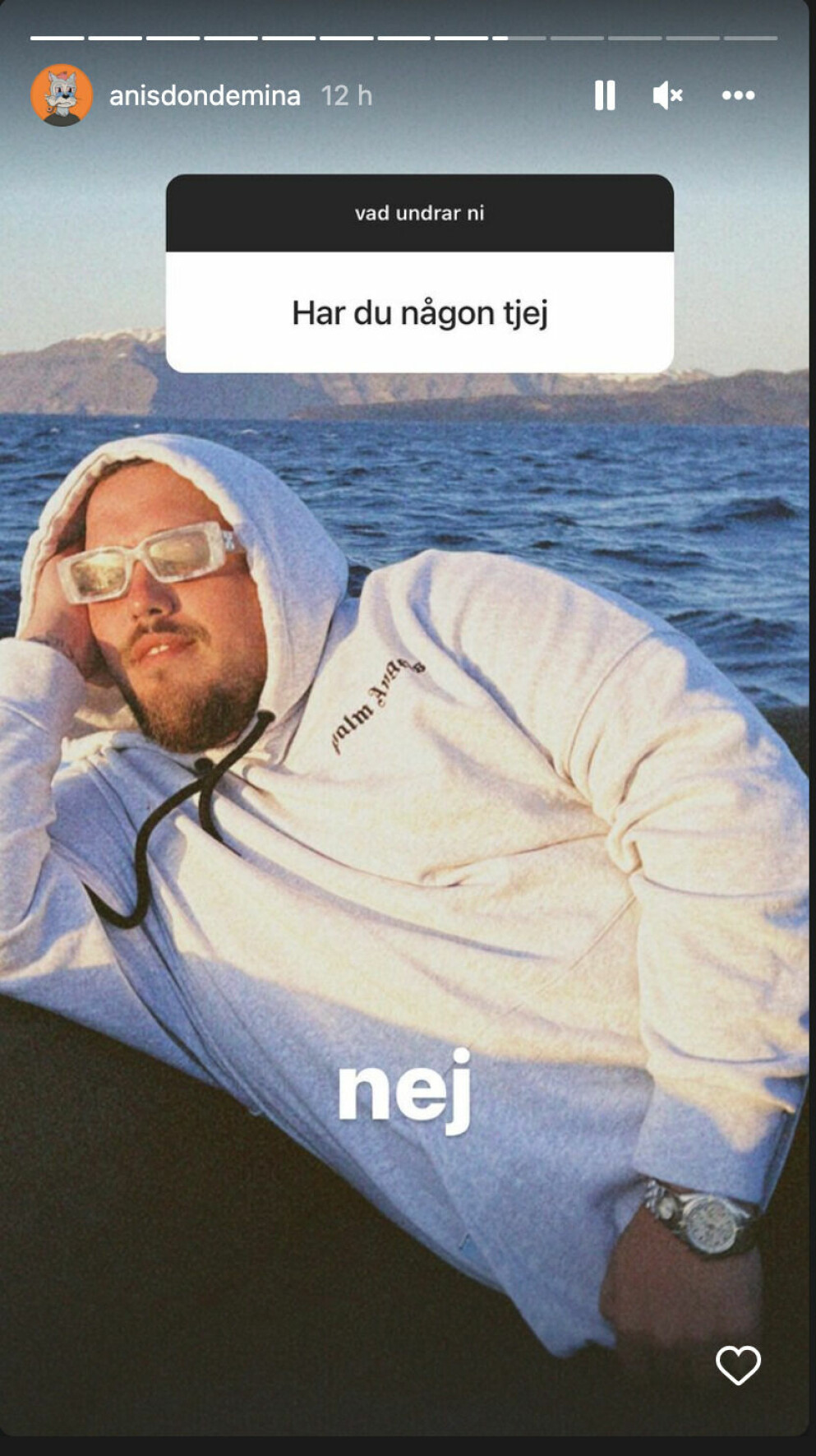 Anis Don Demina svarar på följarens fråga. Anis ligger på en båt i en luvtröja och solglasögon.