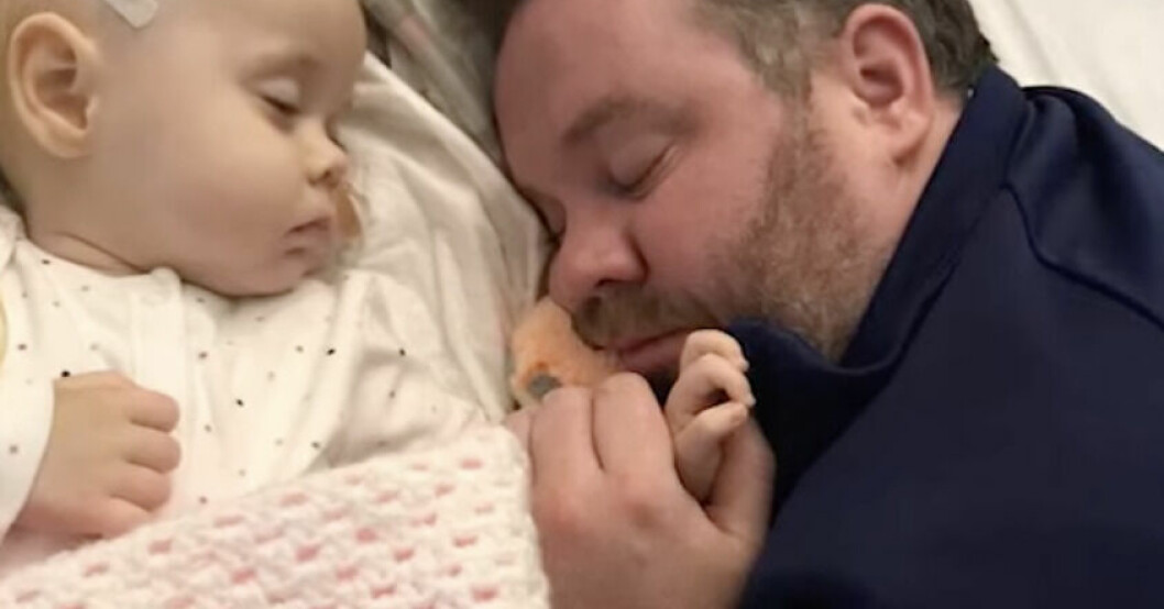 Pappa Andrew håller lilla Roses hand på sjukhuset.