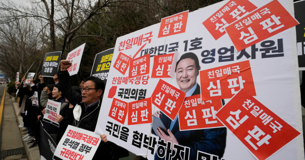 Sydkoreas president Yoon Suk-Yeol ska till Japan. Här syns han på ett plakat vid en av veckans protestaktioner mot honom. Sydkoreas president reser till Japan