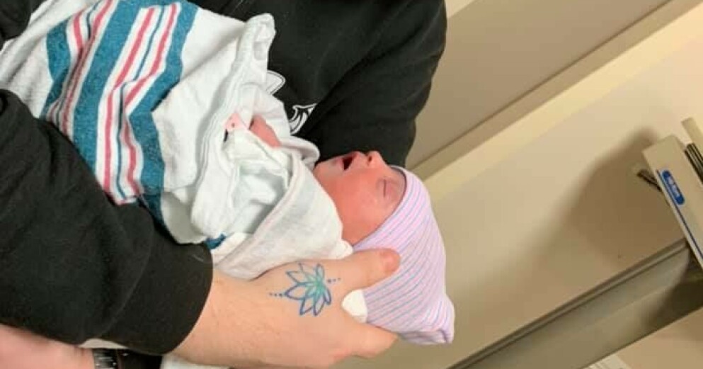 Christopher håller sin nyfödda dotter Luna. Luna
