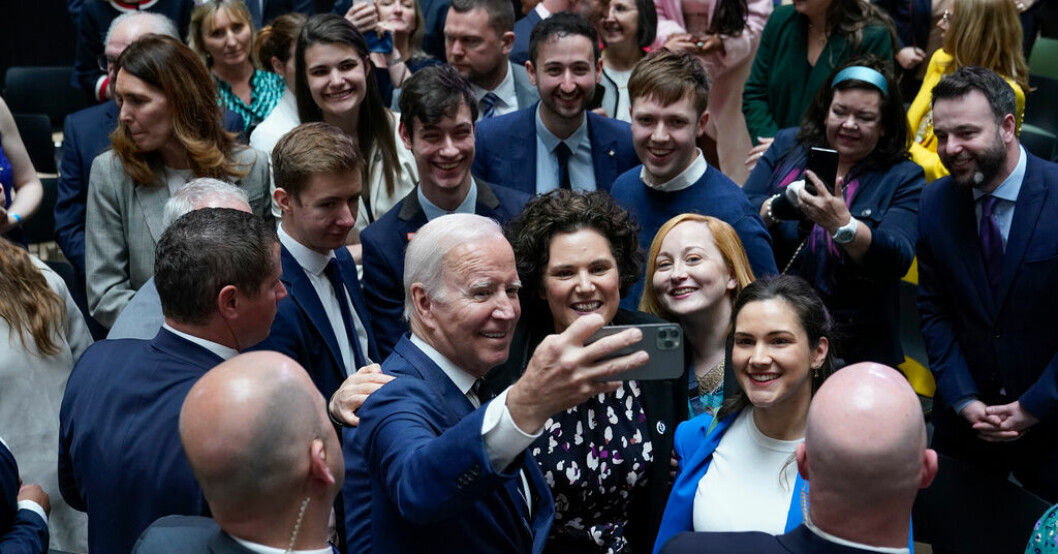 USA:s president Joe Biden tar en selfie med inbjudna gäster på Ulster University i Belfast. Selfies och kritik när Biden kom till Belfast