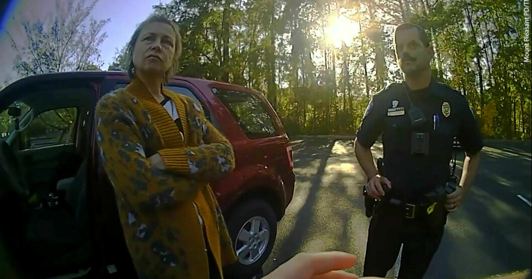 Tamara talar med polismännen framför sin röda bil.